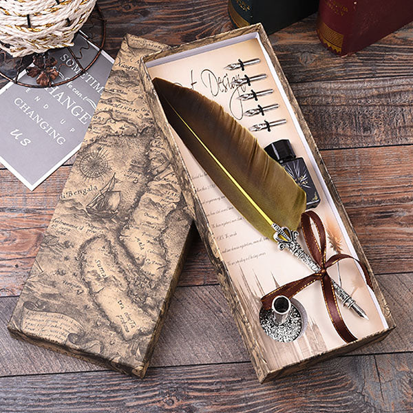 Feather quill pen set with ink bottle in a decorative box on a wooden surface