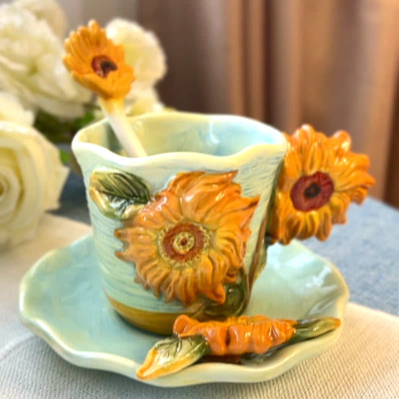 Decorative ceramic cup with sunflower design on a matching saucer.