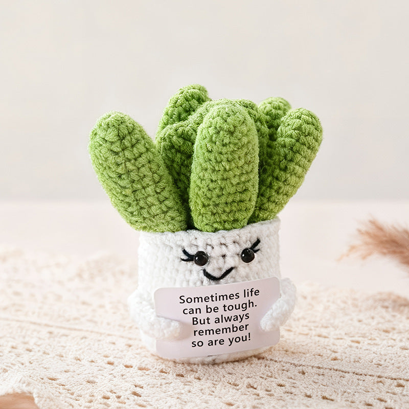 Crocheted succulent plant with a smiling face and motivational message on a light background