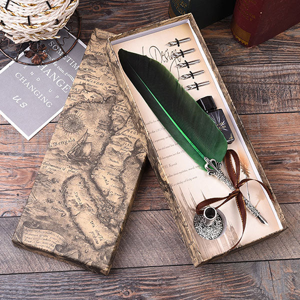 Decorative box with a green feather and decorative elements on a wooden surface