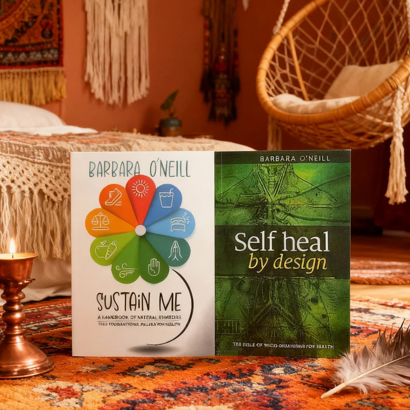 Two books titled 'Sustain Me' and 'Self Heal by Design' on a colorful rug with a cozy room background.