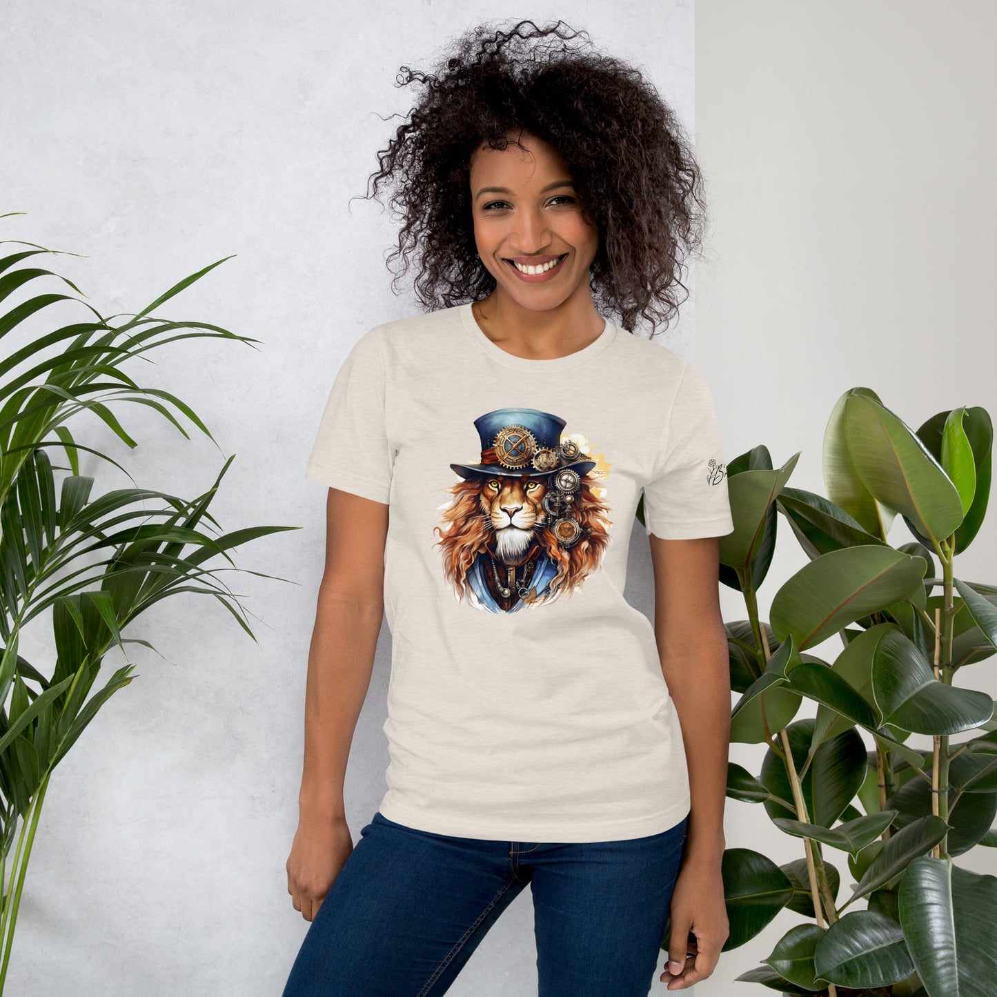 Person wearing a t-shirt with a lion graphic design, standing between two plants against a white wall.