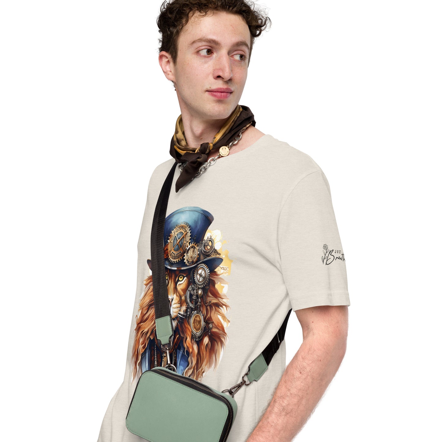 Man wearing a t-shirt with a graphic design of a lion in a top hat and goggles, holding a green bag.