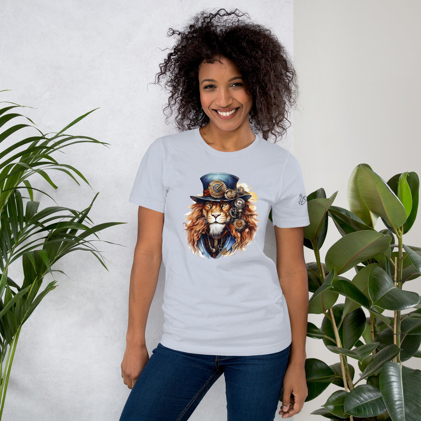 Person wearing a t-shirt with a lion graphic design, standing between two plants against a white wall.
