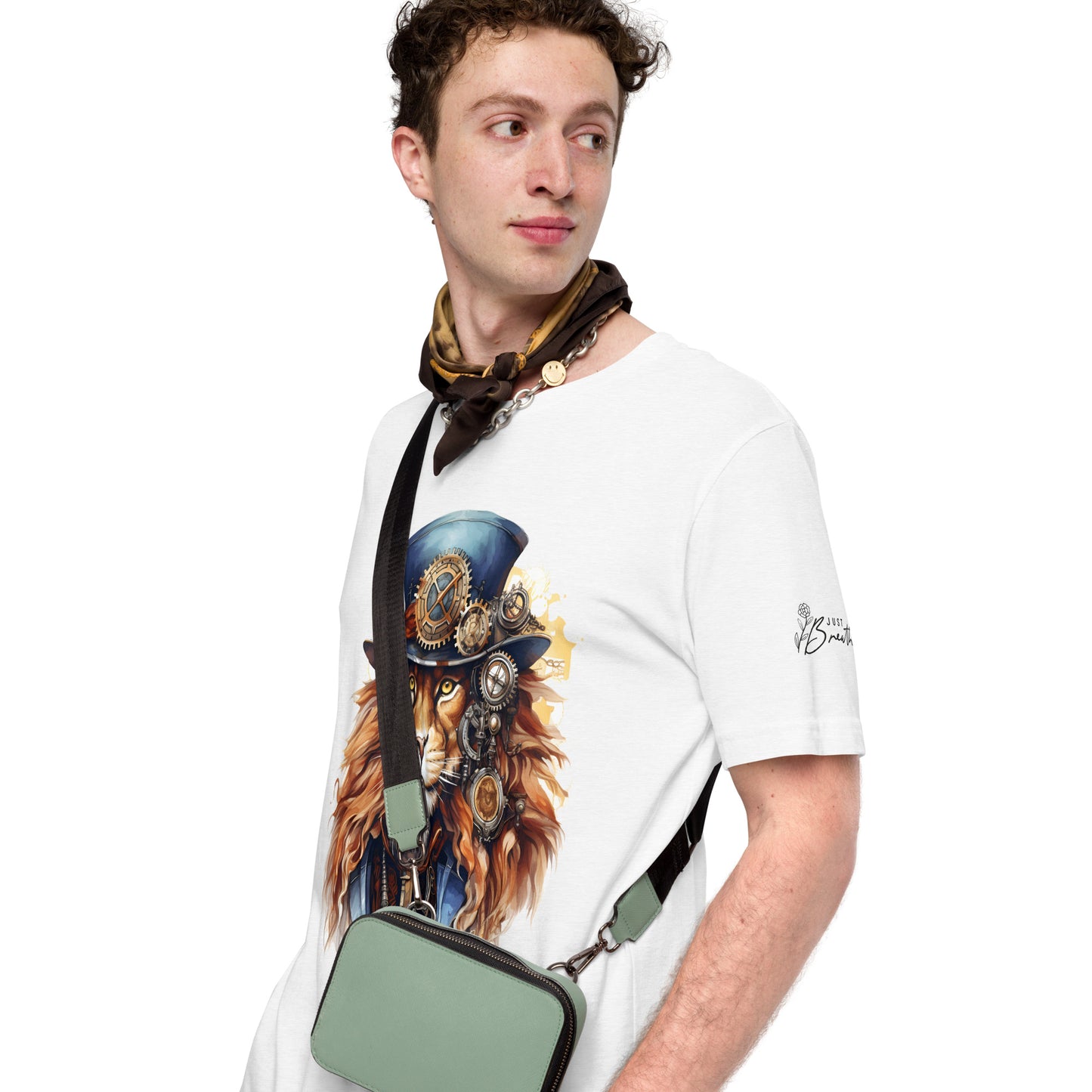 Man wearing a white t-shirt with a graphic design of a lion in a top hat and goggles, holding a green bag.